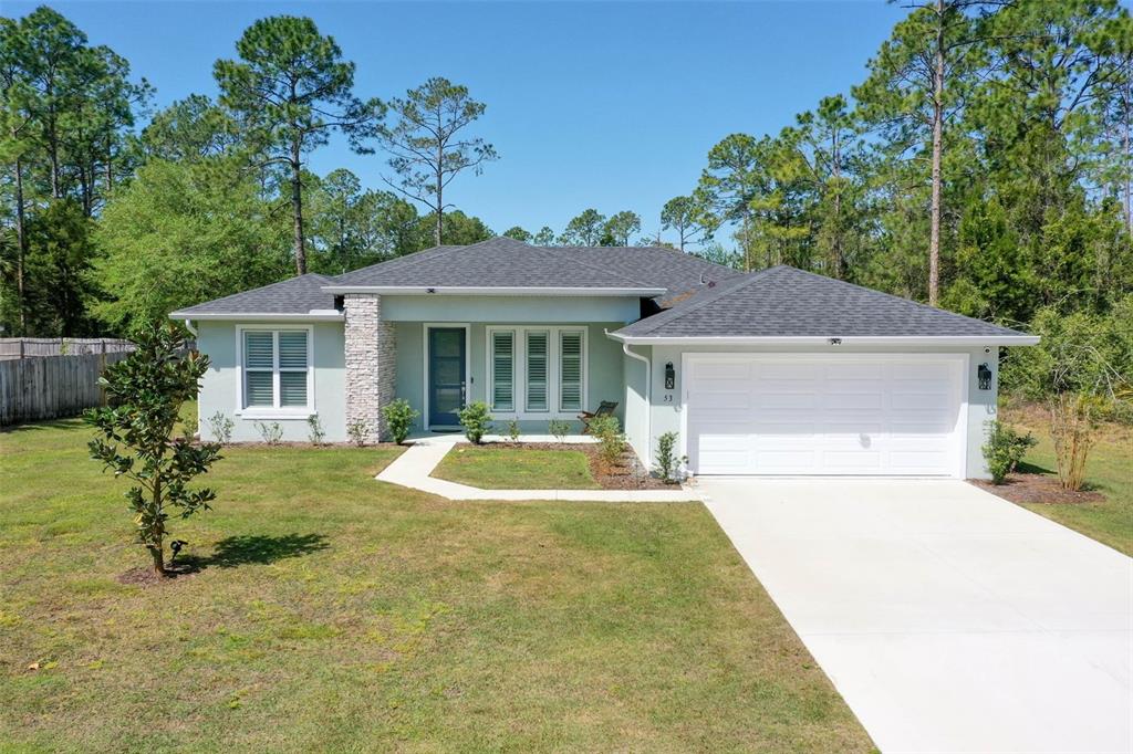 53 Universal Trail Palm Coast, FL 32164 - Photo 1 of 1 a front view of a house with a yard garage and outdoor seating