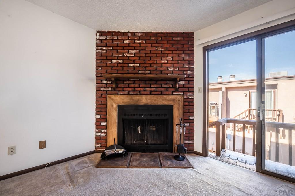 1901 Mohawk Road Pueblo, CO 81001 - Photo 5 of 30 a living room with a fireplace and a floor to ceiling window