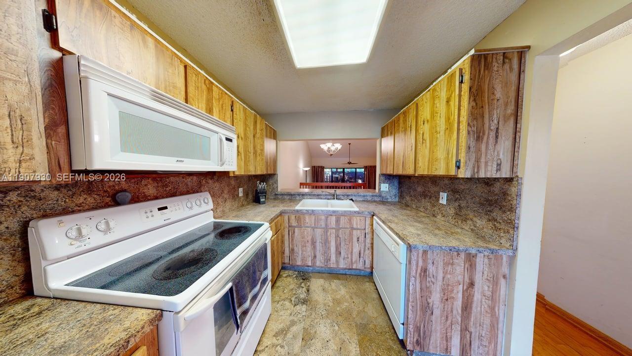 4222 Southwest 87th Terrace Davie, FL 33328 - Photo 29 of 85 a kitchen with a stove a sink and a microwave