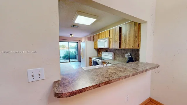 a view of a livingroom with wooden floor and kitchen space