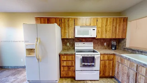a view of an empty room with a kitchen