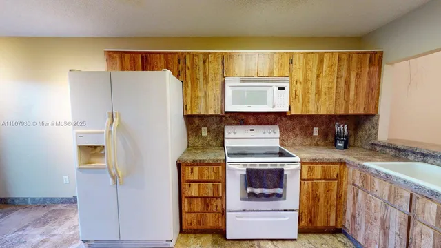 a view of an empty room with a kitchen