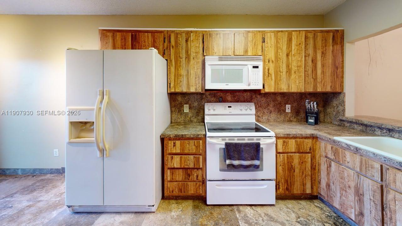 4222 Southwest 87th Terrace Davie, FL 33328 - Photo 72 of 85 a kitchen with stainless steel appliances a stove and a refrigerator