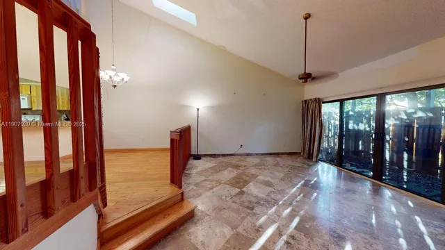 a view of a livingroom with a flesh screen tv and stairs
