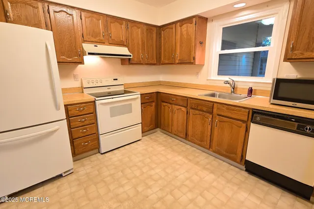 a kitchen with a stove white refrigerator and a sink