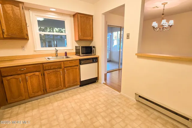 a kitchen with granite countertop a sink cabinets and stainless steel appliances