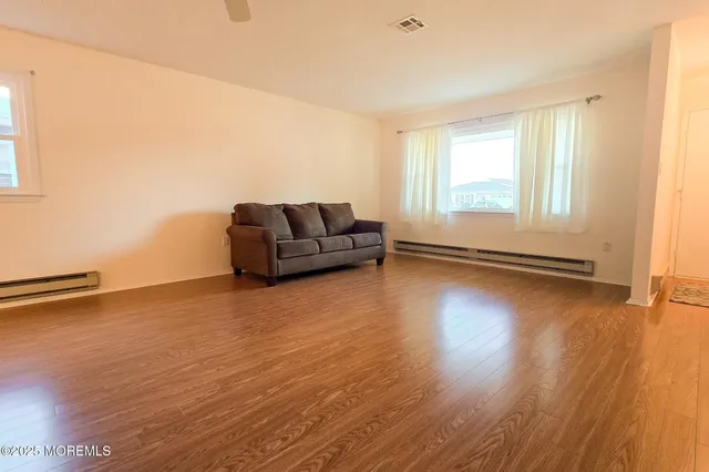 a living room with hard wood floors and a window