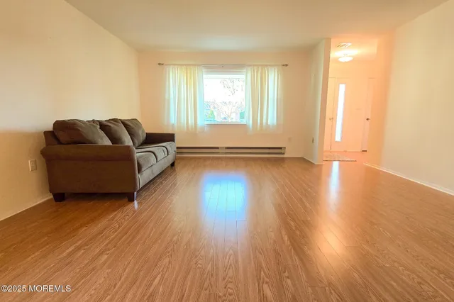 a living room with furniture and a hard wood floor