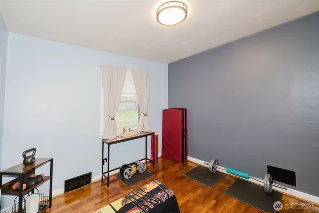 a bedroom with a bed and wooden floor