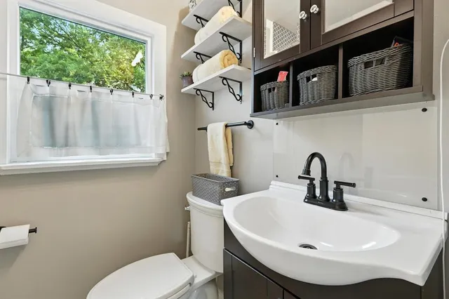 a bathroom with a sink a toilet and a mirror