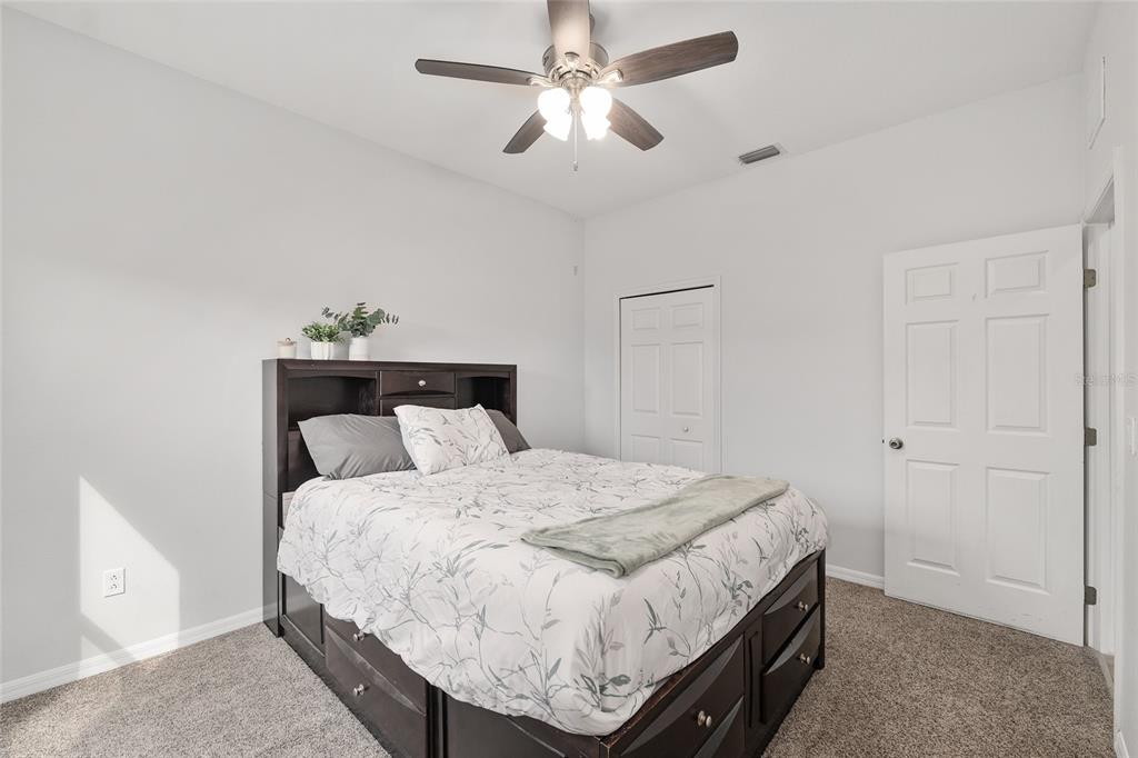 224 Oak Lane Ocala, FL 34472 - Photo 23 of 33 a bedroom with a bed and a chandelier