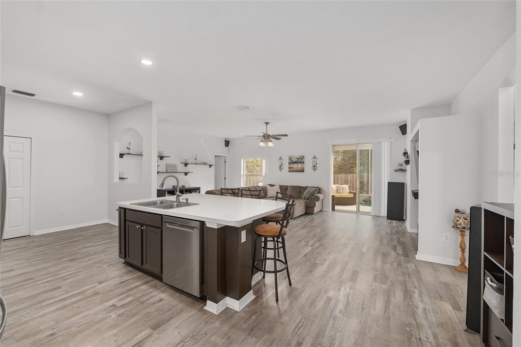 224 Oak Lane Ocala, FL 34472 - Photo 9 of 33 a large kitchen with stainless steel appliances a stove a sink dishwasher and a refrigerator with wooden floor