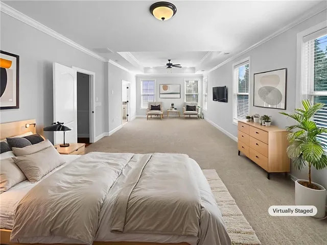 a spacious bedroom with a bed and ceiling fan