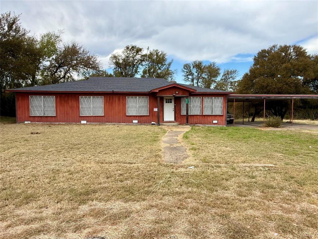 a front view of house with yard and trees in the background