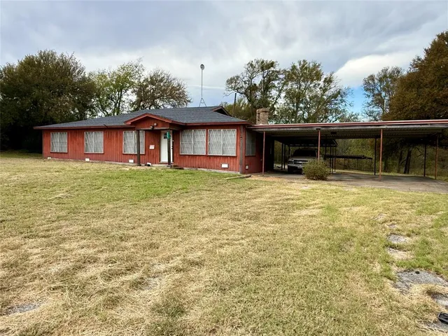 a view of a house with floor to ceiling windows and a yard