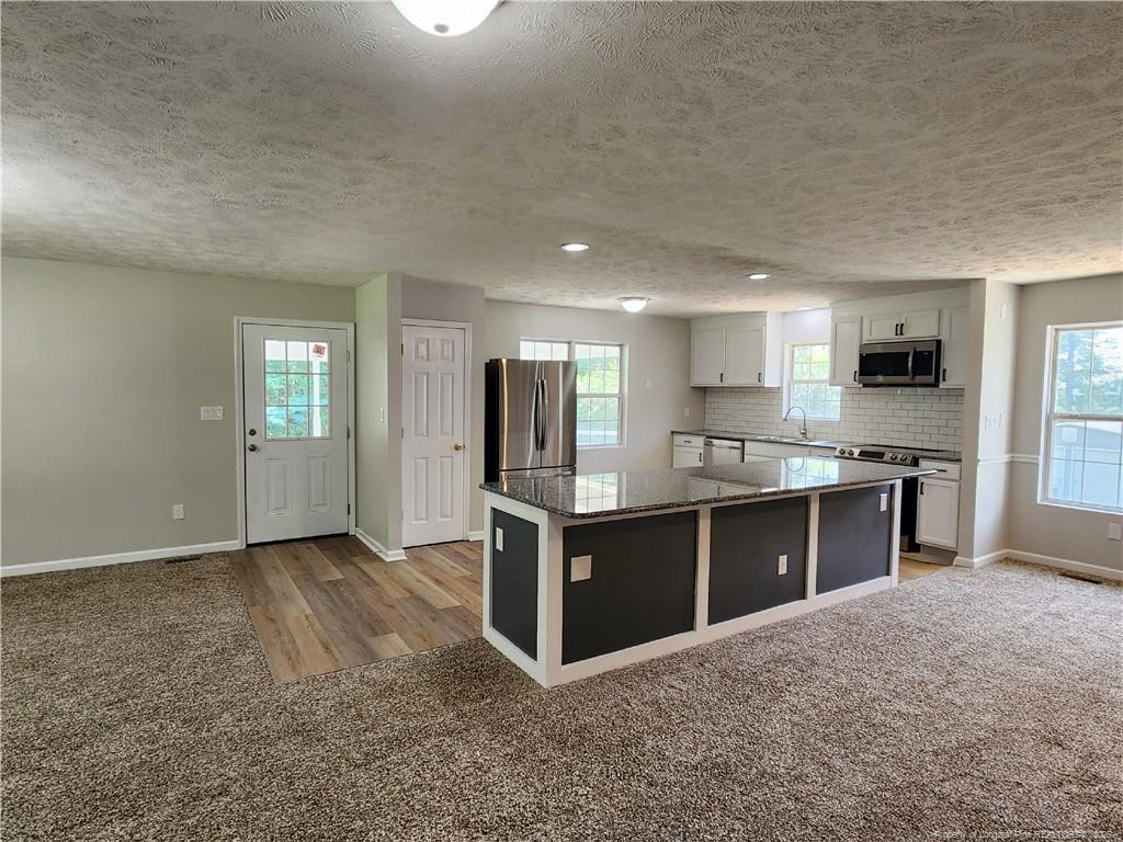 5444 Rockfish Road Raeford, NC 28376 - Photo 11 of 37 a large kitchen with stainless steel appliances granite countertop a stove and a sink