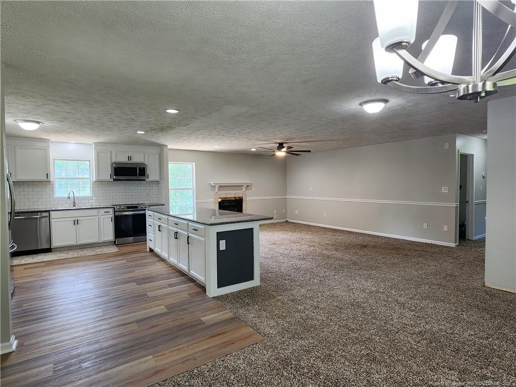 5444 Rockfish Road Raeford, NC 28376 - Photo 12 of 37 a large kitchen with stainless steel appliances a large counter top a stove and a refrigerator