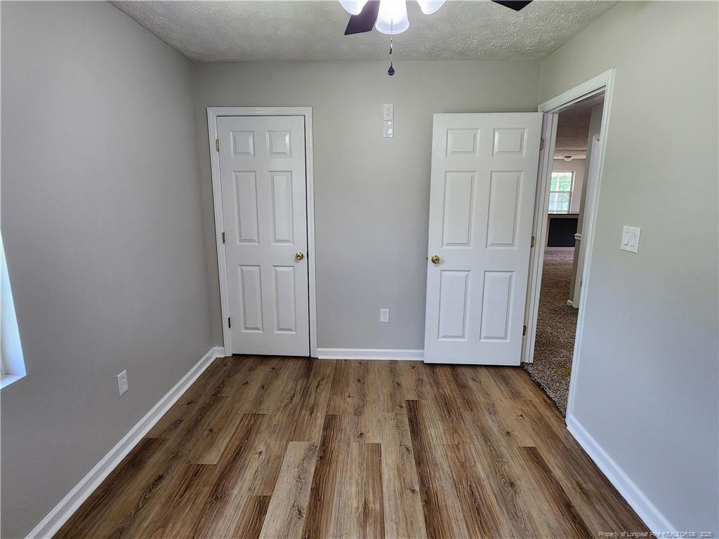 5444 Rockfish Road Raeford, NC 28376 - Photo 21 of 37 a view of a room with wooden floor staircase and a kitchen space