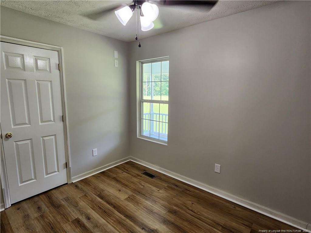 5444 Rockfish Road Raeford, NC 28376 - Photo 29 of 37 a view of empty room with wooden floor and fan