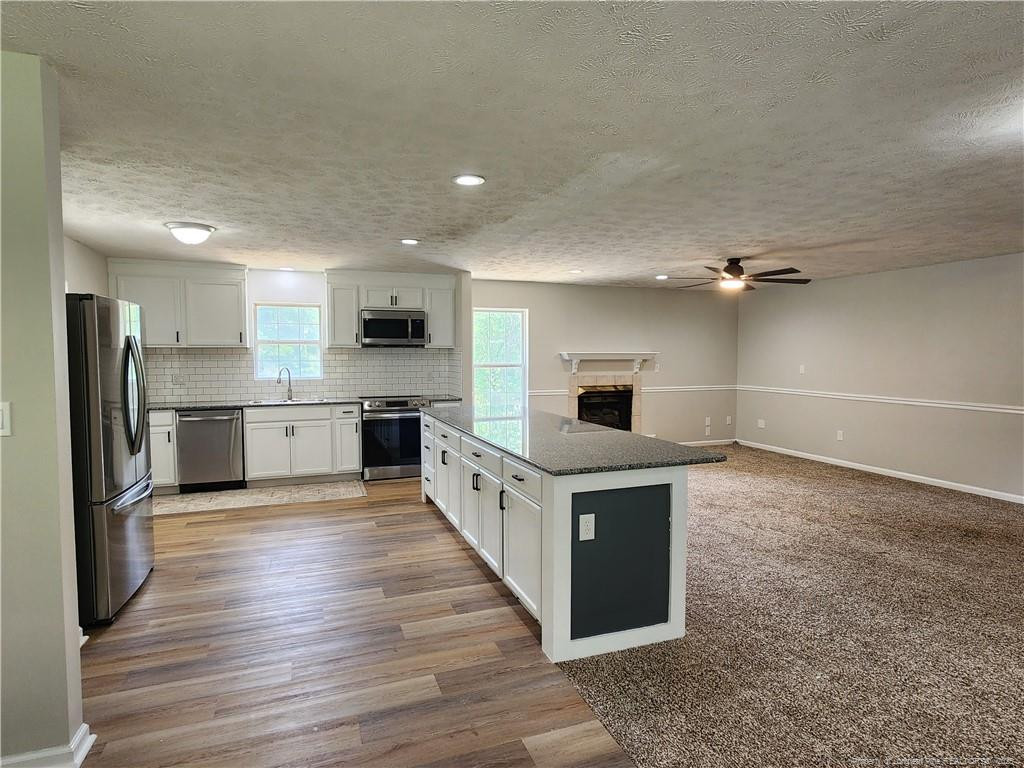 5444 Rockfish Road Raeford, NC 28376 - Photo 6 of 37 a kitchen with stainless steel appliances a refrigerator and a stove top oven