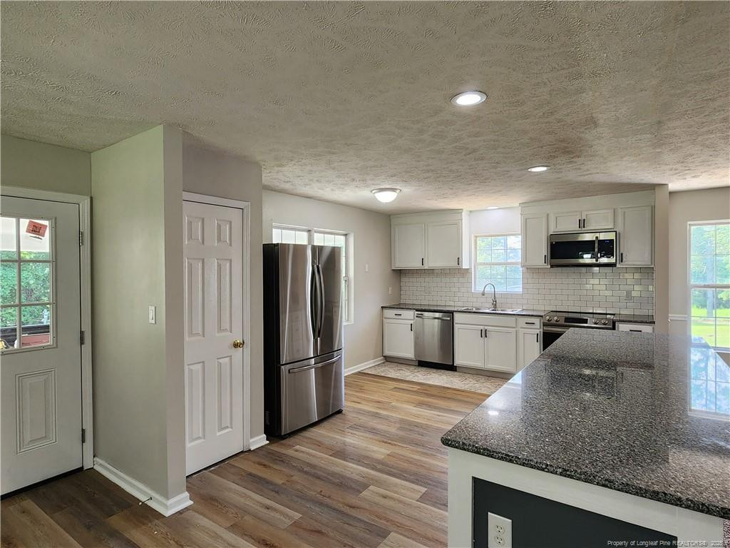 5444 Rockfish Road Raeford, NC 28376 - Photo 8 of 37 a kitchen with stainless steel appliances granite countertop a refrigerator a stove a sink and a microwave