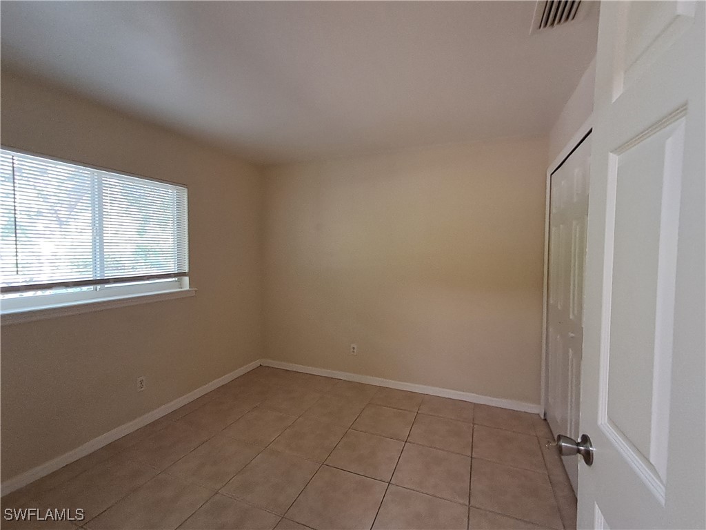 133 Meadow Road Lehigh Acres, FL 33973 - Photo 4 of 12 an empty room with windows