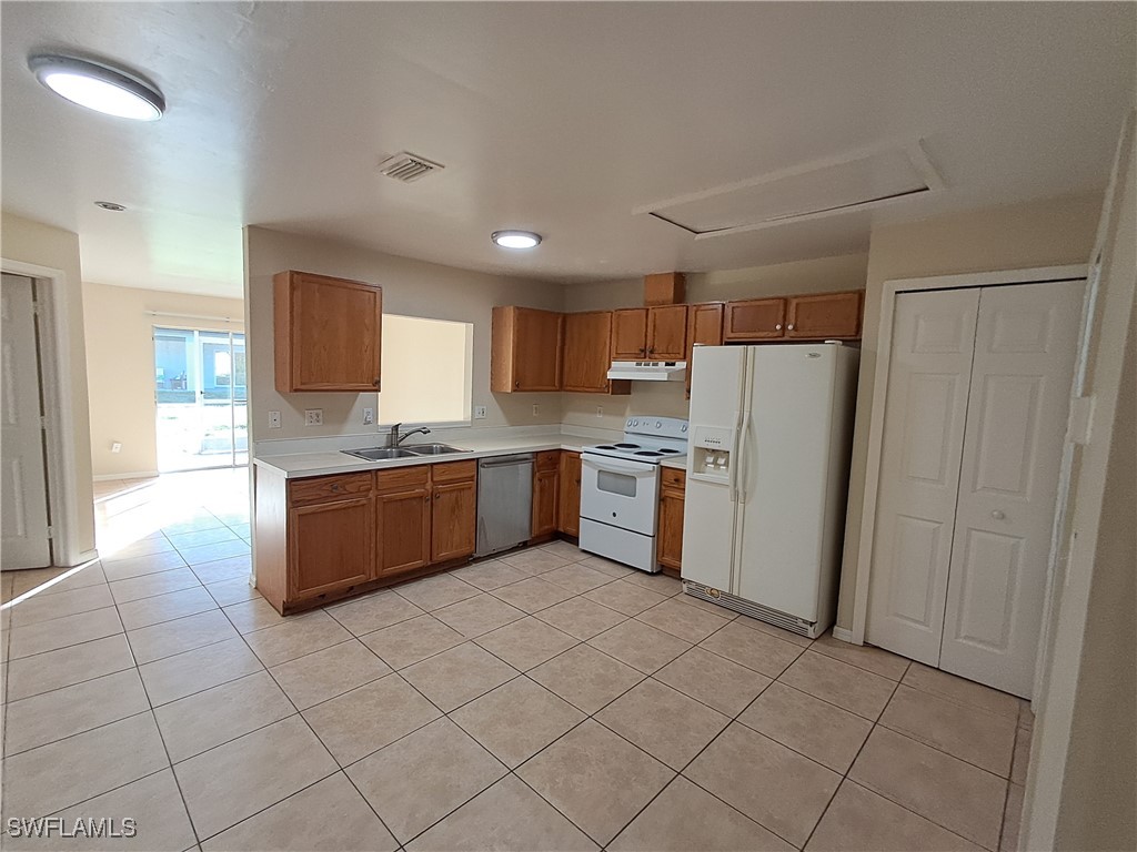 133 Meadow Road Lehigh Acres, FL 33973 - Photo 5 of 12 a kitchen with a cabinets a sink a counter top space and stainless steel appliances