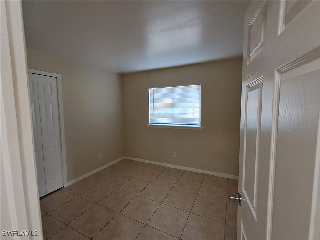 133 Meadow Road Lehigh Acres, FL 33973 - Photo 6 of 12 an empty room with windows