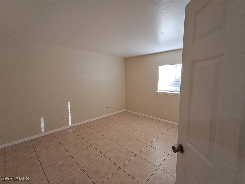 133 Meadow Road Lehigh Acres, FL 33973 - Photo 10 of 12 a view of an empty room and window