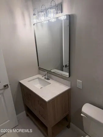 a bathroom with a sink a toilet and mirror