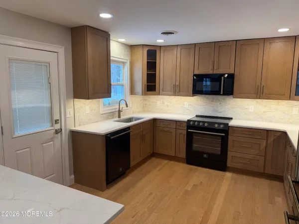 a kitchen with kitchen island wooden cabinets a sink and appliances