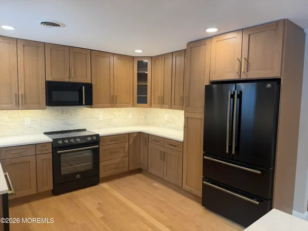 a kitchen with granite countertop stainless steel appliances and wooden cabinets