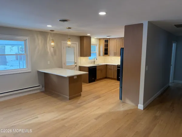 a large kitchen with a window and stainless steel appliances