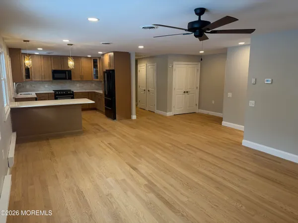 a view of kitchen with kitchen island a sink wooden floor and stainless steel appliances