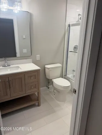 a bathroom with a sink a toilet a mirror and shower