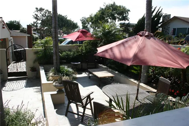 a view of a patio with a table and chairs and potted plants