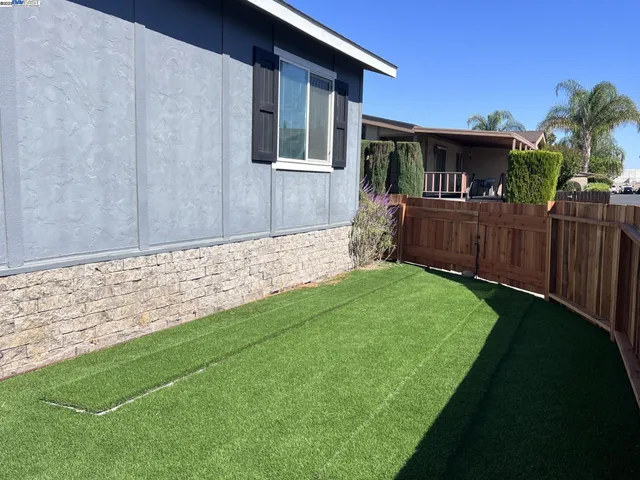 a view of house with backyard and a garden