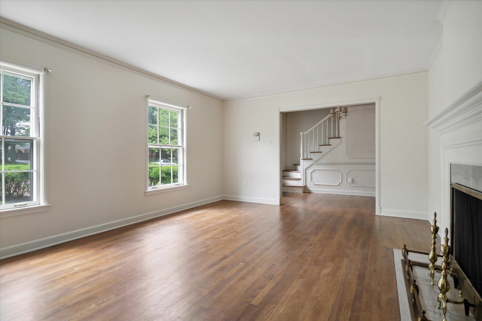 5440 Walnut Grove Road Memphis, TN 38120 - Photo 8 of 25 a view of a room with wooden floor a fireplace and windows