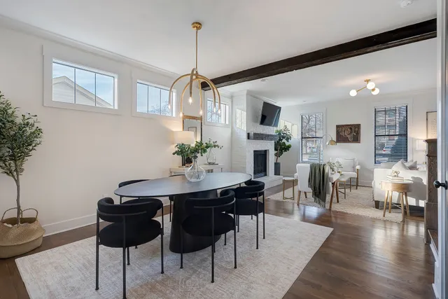 a view of a dining room and livingroom with furniture wooden floor a rug a potted plant and a chandelier