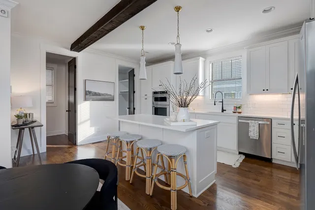 a kitchen with stainless steel appliances kitchen island granite countertop a table chairs sink and cabinets