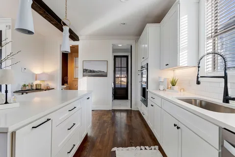 a large kitchen with a lot of counter space and wooden floor