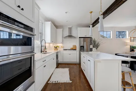a kitchen with white cabinets and white appliances