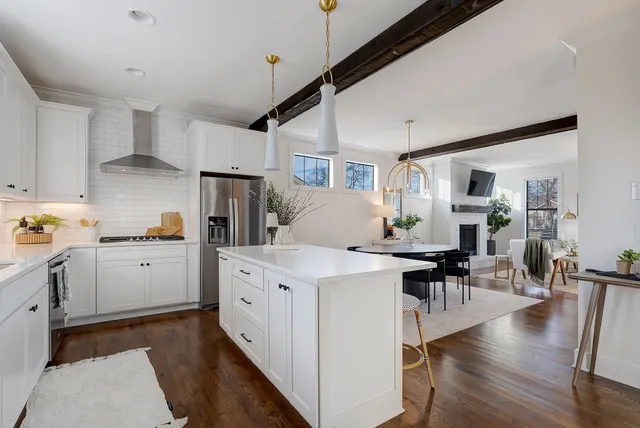 a kitchen with a table chairs stove and wooden floor