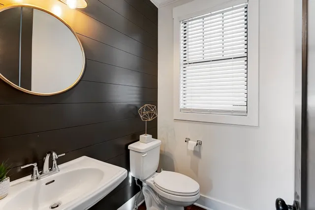 a bathroom with a toilet a sink and a mirror