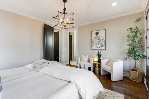 a bedroom with a large bed and a chandelier