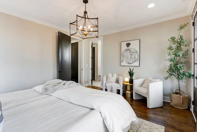 a bedroom with a large bed and a chandelier