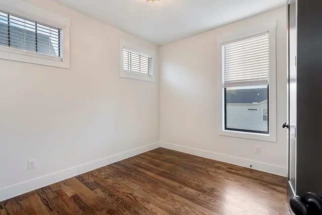 a view of a small space with wooden floor and a window