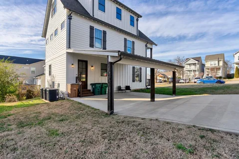 a view of a white house with a yard and plants