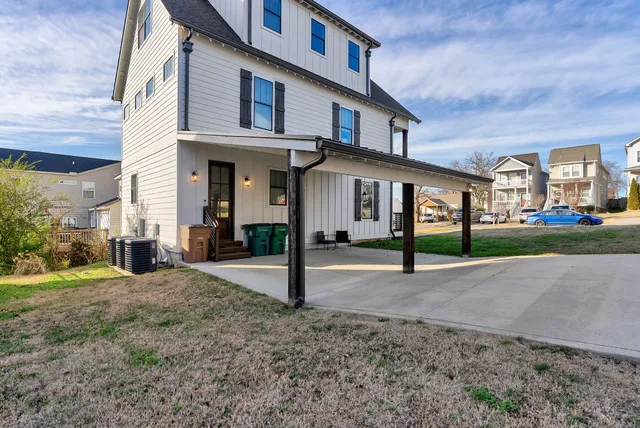 a view of a white house with a yard and plants