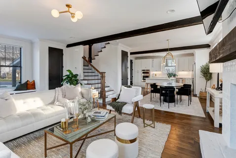a living room with furniture a dining table and a chandelier